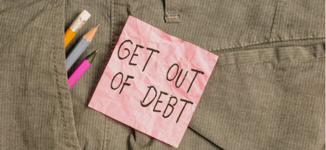 pink note paper inside pocket of man work trousers "Get Out Of Debt".